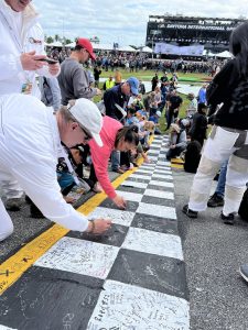 Fans Sign the Finish Line Before the Race